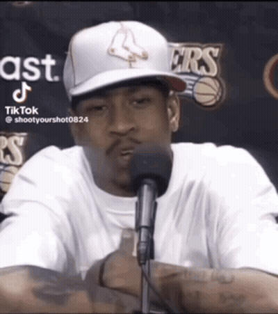 A Man Wearing A Boston Red Sox Hat Is Sitting In Front Of A Microphone GIF
