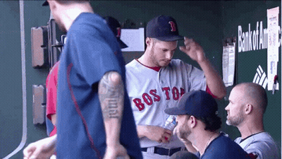 A Man Wearing A Boston Red Sox Jersey Talks To A Group Of Men GIF