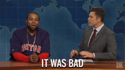 A Man Wearing A Boston Red Sox Shirt Is Sitting Next To A Man In A Suit GIF