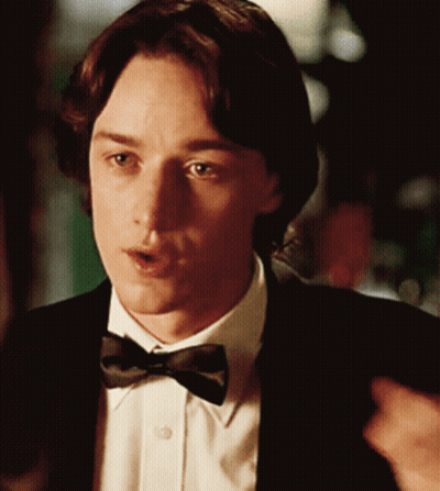 A Man Wearing A Bow Tie And A Suit Looks At Something GIF