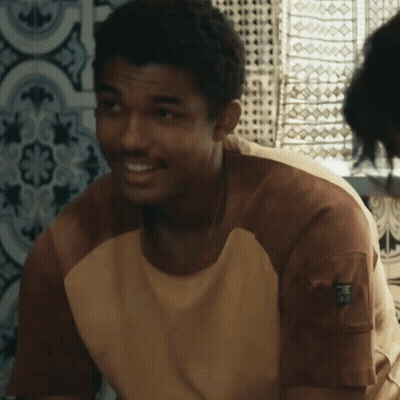 A Man Wearing A Brown And White Shirt With A Pocket On The Sleeve That Says ' R.i.p. ' GIF