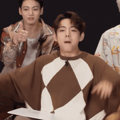 A Man Wearing A Brown And White Sweater With A Microphone On His Neck GIF