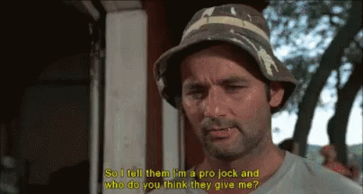 A Man Wearing A Bucket Hat Is Talking To Another Man . GIF