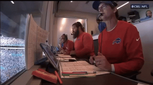 A Man Wearing A Buffalo Bills Sweatshirt Sits In A Booth GIF