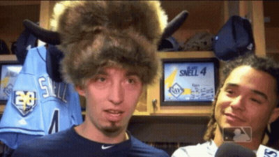 A Man Wearing A Buffalo Hat Is Standing Next To A Man Wearing A Jersey That Says Smell 4 GIF