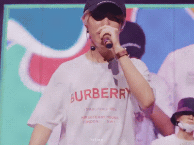 A Man Wearing A Burberry Shirt Singing Into A Microphone GIF