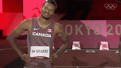 A Man Wearing A Canada Jersey Is Standing In Front Of A Tokyo 2020 Sign GIF
