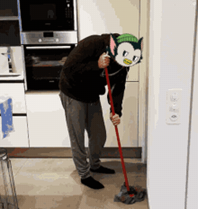 A Man Wearing A Cat Mask Is Mopping The Floor In A Kitchen GIF