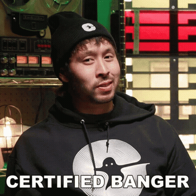 A Man Wearing A Certified Banger Hoodie Stands In Front Of A Record Player GIF