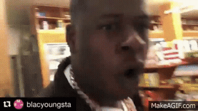 A Man Wearing A Chain Around His Neck Is Making A Funny Face . GIF