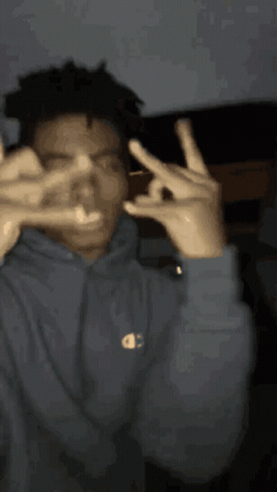 A Man Wearing A Champion Hoodie Is Making A Peace Sign With His Hands GIF