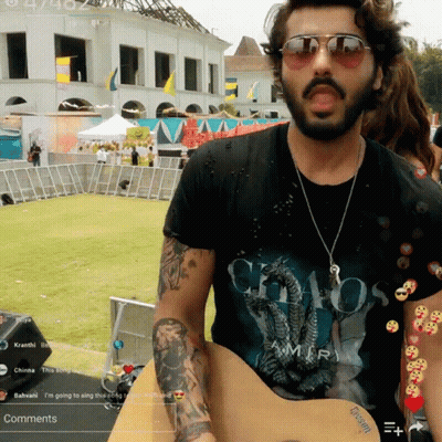 A Man Wearing A Chaos Amiri T-Shirt Is Playing A Guitar GIF