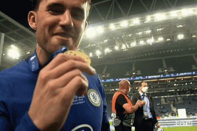 A Man Wearing A Chelsea Jersey Holds A Medal In His Hand GIF