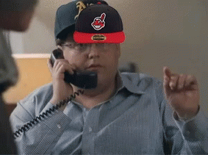 A Man Wearing A Cleveland Indians Hat Talks On A Phone GIF
