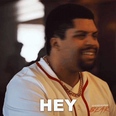 A Man Wearing A Cocaine Gear Shirt Is Smiling And Saying Hey GIF