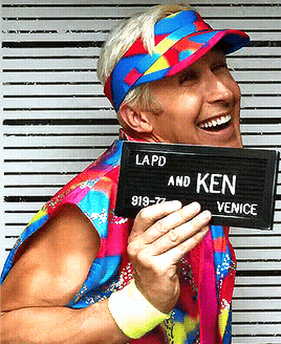 A Man Wearing A Colorful Hat And Holding A Sign That Says Lapd And Ken GIF