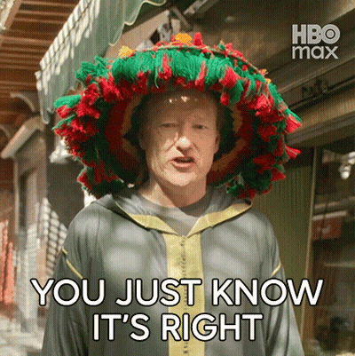 A Man Wearing A Colorful Hat Is Standing In Front Of A Building And Says `` You Just Know It 'S Right '' . GIF