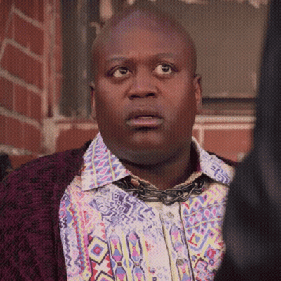 A Man Wearing A Colorful Shirt And A Chain Around His Neck GIF
