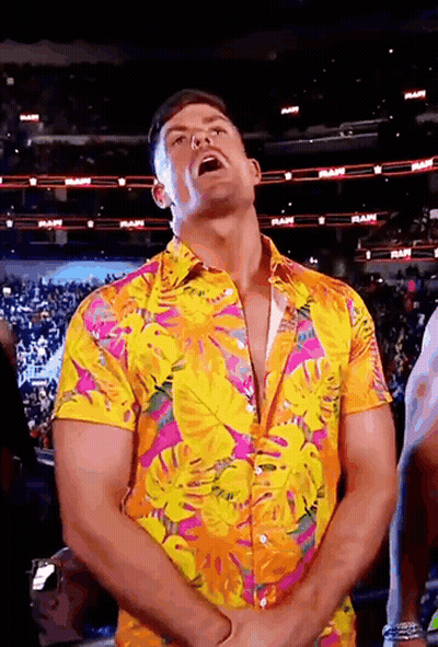 A Man Wearing A Colorful Shirt Is Standing In Front Of A Crowd In A Stadium . GIF
