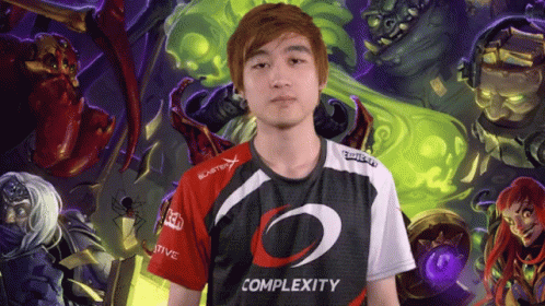 A Man Wearing A Complexity Shirt Is Standing In Front Of A Painting GIF