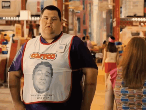 A Man Wearing A Costco Apron Is Standing In Front Of A Woman GIF