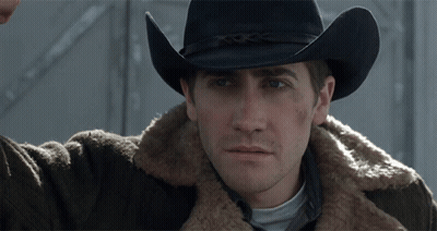 A Man Wearing A Cowboy Hat And A Brown Jacket GIF