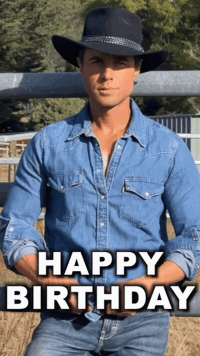 A Man Wearing A Cowboy Hat And A Denim Shirt Is Sitting In Front Of A Fence And Says Happy Birthday GIF