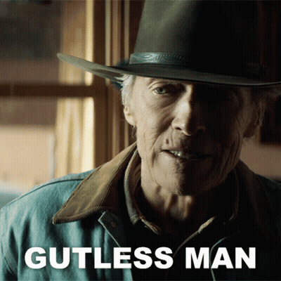 A Man Wearing A Cowboy Hat And A Jacket With Gutless Man Written On It GIF