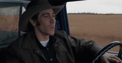 A Man Wearing A Cowboy Hat And A Leather Jacket Is Driving A Car GIF
