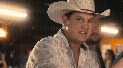 A Man Wearing A Cowboy Hat And A Shirt With Flowers On It GIF