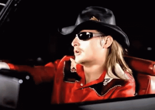 A Man Wearing A Cowboy Hat And Sunglasses Is Sitting In A Car . GIF