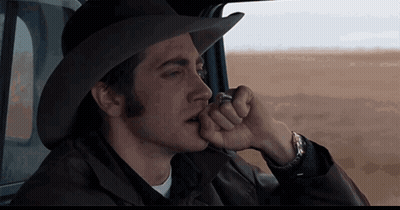 A Man Wearing A Cowboy Hat Is Sitting In A Car Smoking A Cigarette GIF