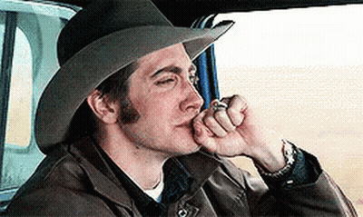 A Man Wearing A Cowboy Hat Is Smoking A Cigarette In A Car GIF