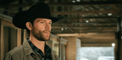 A Man Wearing A Cowboy Hat Is Standing In A Building GIF