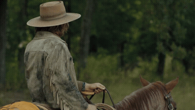 A Man Wearing A Cowboy Hat Rides A Horse GIF