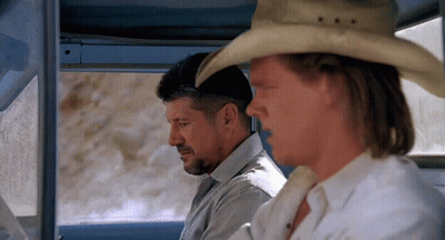 A Man Wearing A Cowboy Hat Sits Next To Another Man GIF