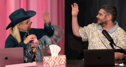 A Man Wearing A Cowboy Hat Talks Into A Microphone Next To A Box Of Tissues And An Apple Laptop GIF