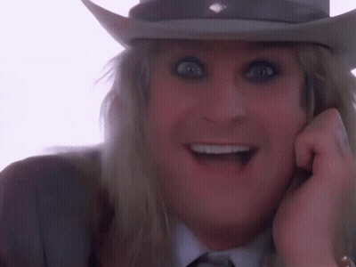 A Man Wearing A Cowboy Hat With His Tongue Out GIF