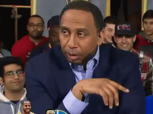 A Man Wearing A Cowboys Hat Is Sitting In A Crowd Of People GIF