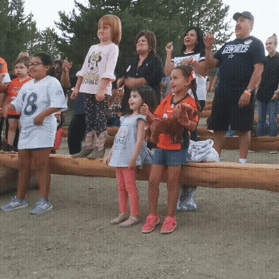 A Man Wearing A Cowboys Shirt Stands Behind A Group Of Children GIF