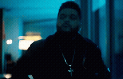 A Man Wearing A Cross Necklace And A Black Jacket GIF