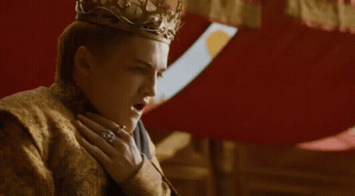 A Man Wearing A Crown And A Gold Robe Is Standing Next To A Woman In A Room . GIF