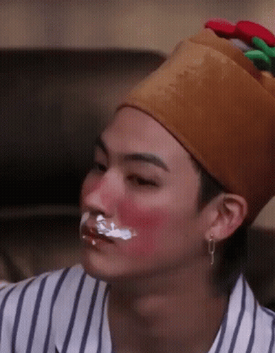 A Man Wearing A Crown And A Striped Shirt Has Icing On His Face And Nose . GIF
