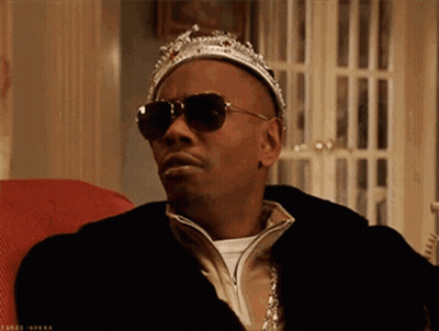 A Man Wearing A Crown And Sunglasses Is Sitting On A Couch . GIF