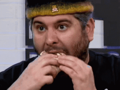 A Man Wearing A Crown Is Eating A Hamburger . GIF