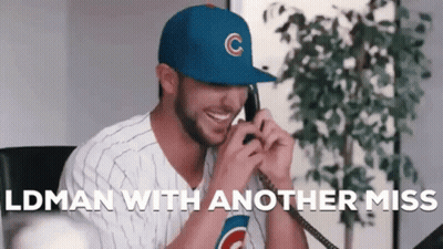 A Man Wearing A Cubs Hat Is Talking On A Phone While Smiling . GIF