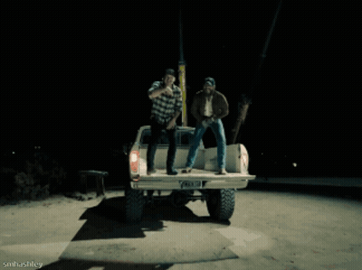 A Man Wearing A Dallas Hat Is Laughing While Sitting Next To Another Man GIF