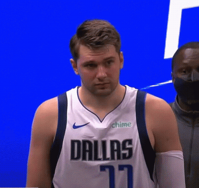 A Man Wearing A Dallas Jersey Is Standing In Front Of A Blue Wall . GIF