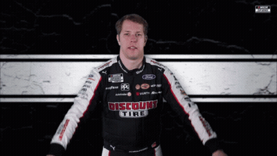 A Man Wearing A Discount Tire Shirt Holds A Checkered Flag GIF