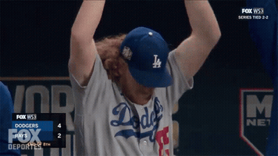 A Man Wearing A Dodgers Hat Holds His Arms Up GIF